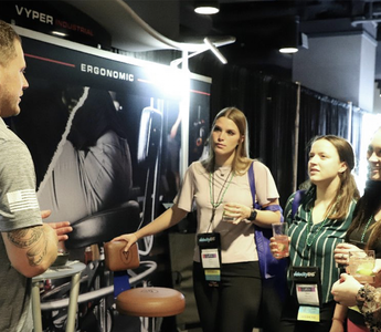 guy in gray shirt address four women at a conference